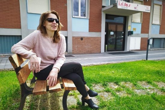 La presidente Gigliola Chiappini seduta su una panchina nel giardino esterno della sede UICI
