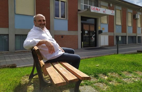 Mirco Fava seduto su una panchina del parco esterno alla sede UICI
