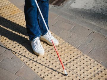 blind man walking on loges with a cane