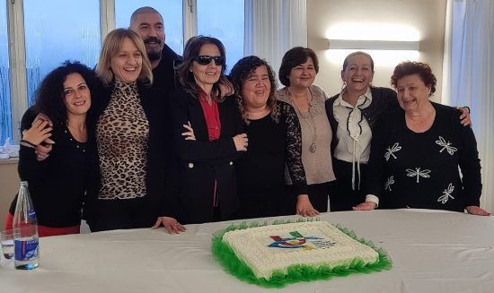 Le socie di Uici Marche festeggiano la prima assemblea in presenza. Intorno a un tavolo con la centro una bella torta decorata con il logo Uici