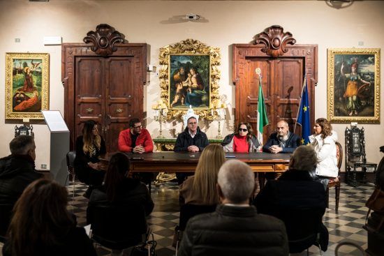 I responsabili del progetto sono seduti al tavolo della bellissima Sala Ceci per la conferenza stampa. Al centro la presidente Gigliola Chiappini con maglia rossa e piumino chiaro