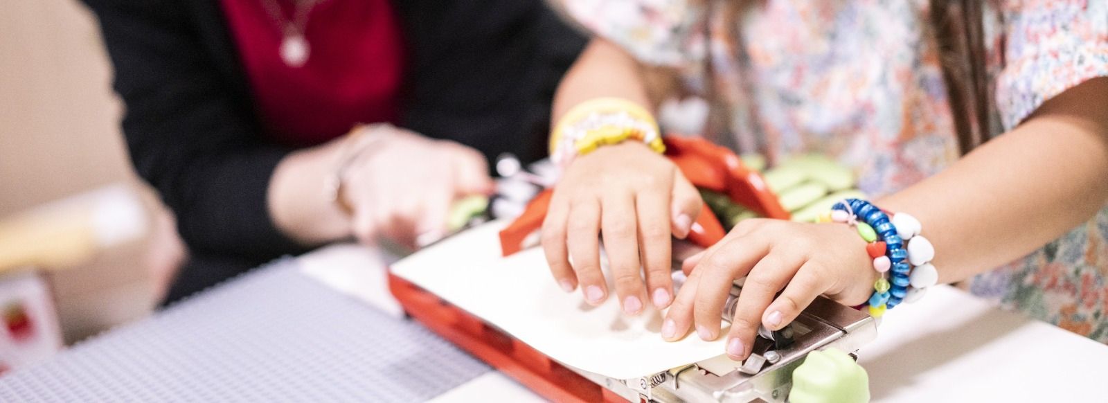 mani di una bimba che leggono in braille